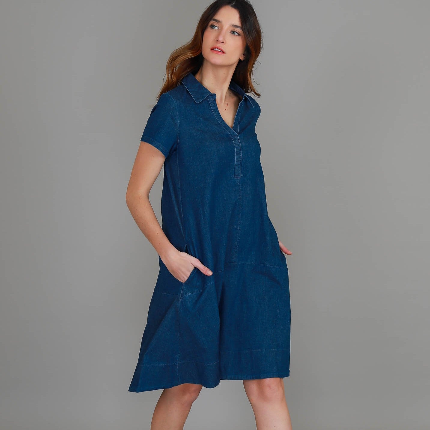 Woman wearing a blue dress against a gray background